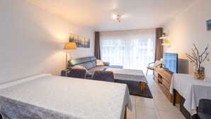 Una habitación de hotel con cama, sofá, escritorio y televisión.