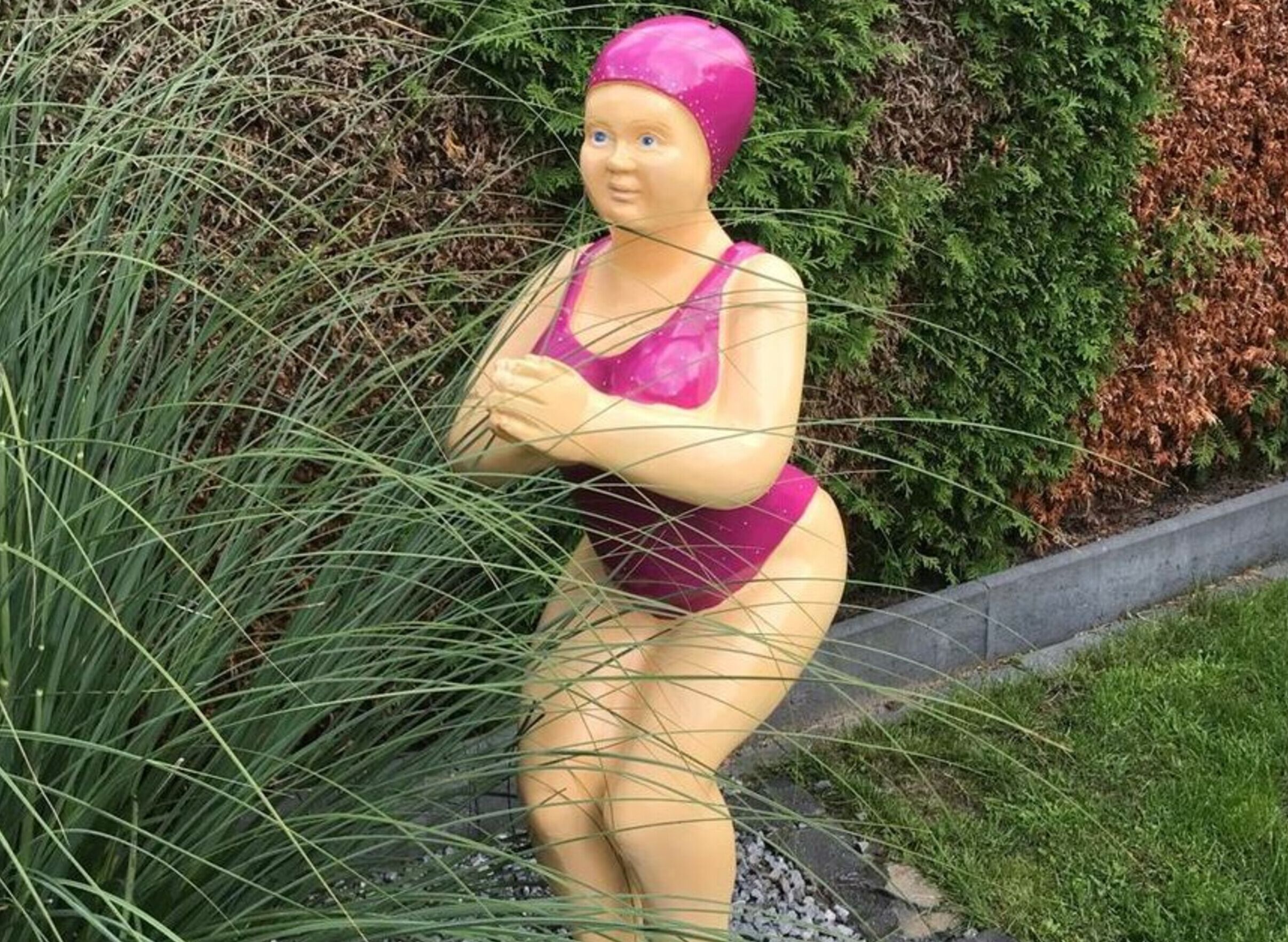 Una estàtua d'una persona amb banyador al jardí.