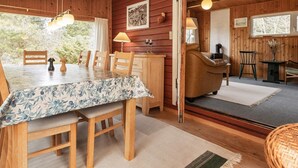 Ein Holzhütten-Interieur mit Essbereich, einer Couch und einem Kamin.