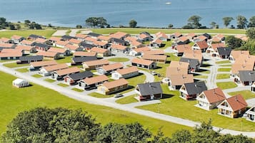 Ein Wohngebiet mit reihenweise angeordneten Häusern, ein Yachthafen mit Booten und im Hintergrund ein Gewässer.