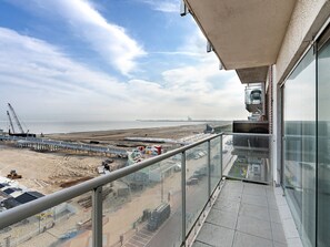 Un balcon donnant sur un chantier de construction et une plage.