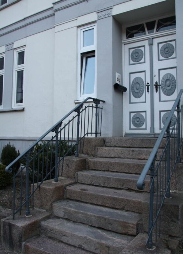 A building with a set of stone steps leading to a door with decorative circular patterns. - Maisonette to Gottorf and Schlei (Schleswig)