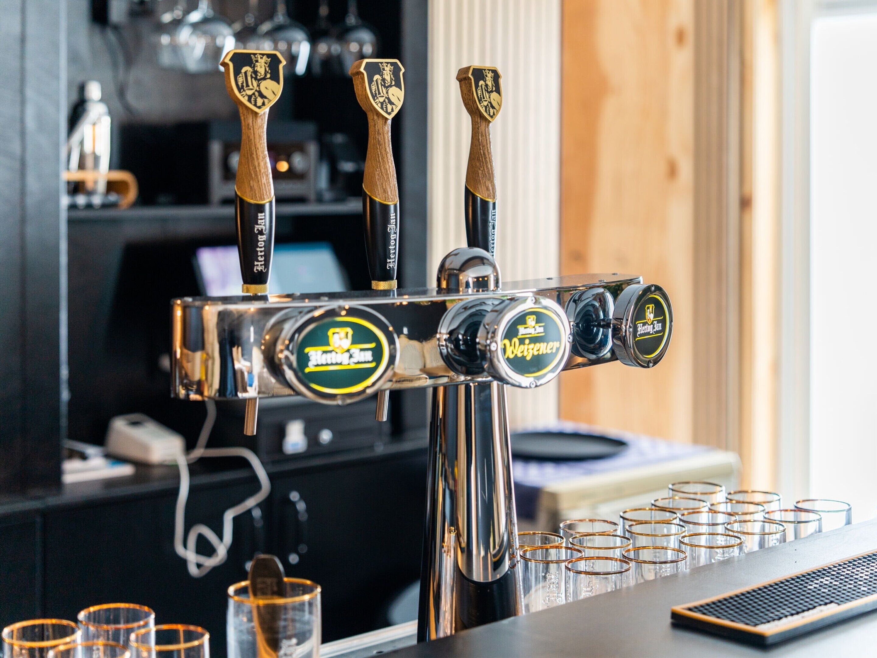 A bar with a tap labeled "Hertog Jan" and "Weizenbier."