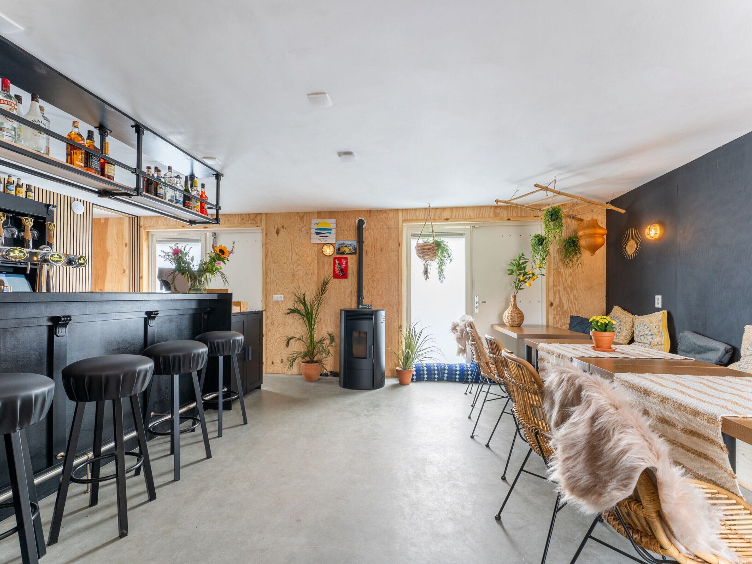A modern kitchen with a bar area, wooden accents, and a central island.