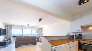 Een moderne keuken met witte kasten, een houten aanrecht en een ingebouwde oven.