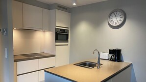 A modern kitchen with a built-in oven, a sink, and a coffee maker. - Apartment in Nieuwpoort Near the Beach (Nieuwpoort)