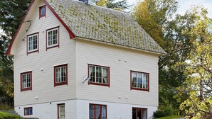 Un edificio blanco de dos pisos con detalles en rojo y numerosas ventanas.