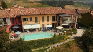 A large villa with a swimming pool, outdoor seating, and a windmill. - Apartment Milleluci 2 (Monforte d'Alba)