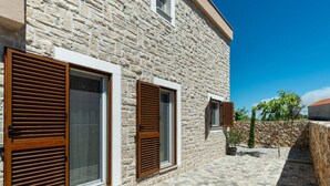 A stone building with large windows and shutters, a paved courtyard, and a stone wall. - With Pool, Jacuzzi and Sauna (Privlaka)
