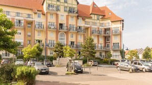 A multi-story residential building with balconies, a parking lot, and surrounding greenery. - Apartment in Nieuwpoort Near the Beach (Nieuwpoort)