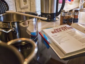 A kitchen with stainless steel cookware, a cookbook, and salt and pepper shakers on the counter. - Idyll Near Limburg/lahn (Hünfelden)
