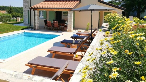 A two-story house with a swimming pool, outdoor seating, and a garden with yellow flowers. - Villa Stella Comfortable Holiday Residence (Umag)