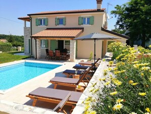 A two-story house with a swimming pool, outdoor seating, and a garden with yellow flowers. - Villa Stella Comfortable Holiday Residence (Umag)