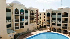 A hotel with multiple balconies, a central swimming pool, and a courtyard area. - Belvilla by OYO Apartment in Santa Pola (Santa Pola)