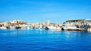 A marina with several boats docked, a clear blue sky, and buildings in the background. - Belvilla by OYO Apartment in Santa Pola (Santa Pola)