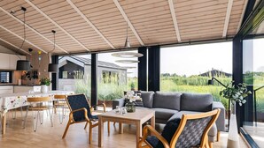 A spacious living area with a dining table, chairs, and a sofa. - 5 Star Holiday Home in Hirtshals (Hirtshals)