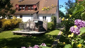 A house with a sloped roof, a satellite dish, and a small deck with outdoor furniture. - Apartment in Lancken-granitz (Lancken-Granitz)
