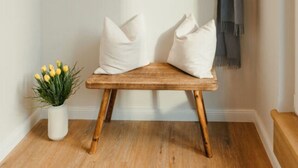A small, cozy room with a wooden bench, a coat rack, and a potted plant. - Utkiek Stuuv Comfortable Holiday Residence (Ratzeburg)