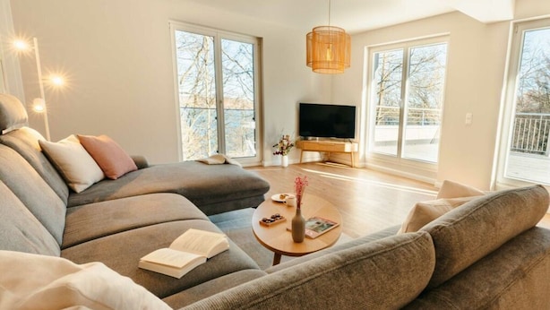 A modern living room with a large sectional sofa, a coffee table, and a flat-screen TV. - Utkiek Stuuv Comfortable Holiday Residence (Ratzeburg)