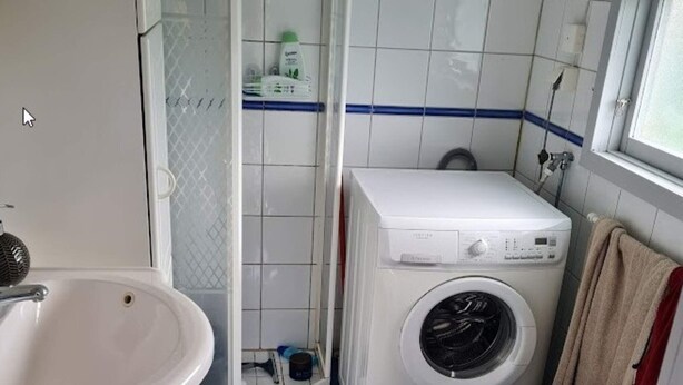 A compact bathroom with a white sink, a washing machine, and a toilet. - 4 Star Holiday Home in Skarhamn (Kyrkesund)