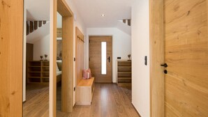 A wooden interior hallway with a bench, shelves, and a door leading to another room. - Holiday Home Hutterwirtshof (Moso in Passiria)