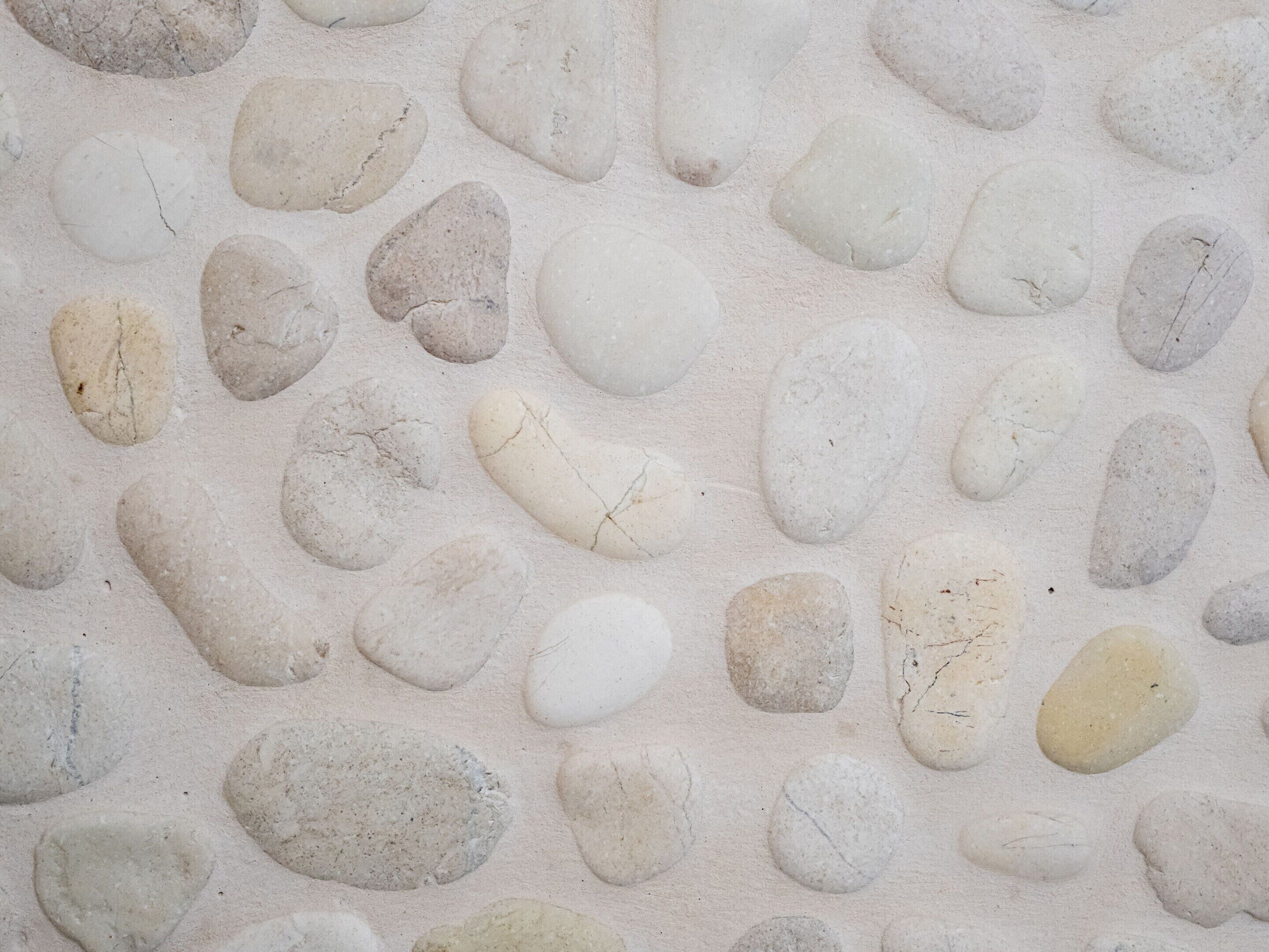 A close-up of a textured surface with irregularly shaped stones embedded in a light-colored material.