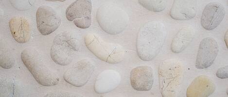 A close-up of a textured surface with irregularly shaped stones embedded in a light-colored material.
