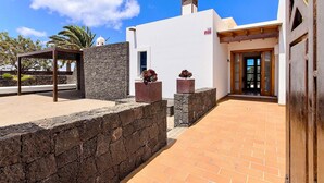 Un edificio moderno con fachada blanca, pared de piedra y puerta de madera.