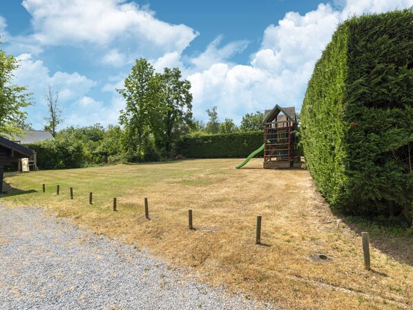 A playground with a slide and a wooden playhouse. - Chalet Comfort Near Durbuy (Durbuy)