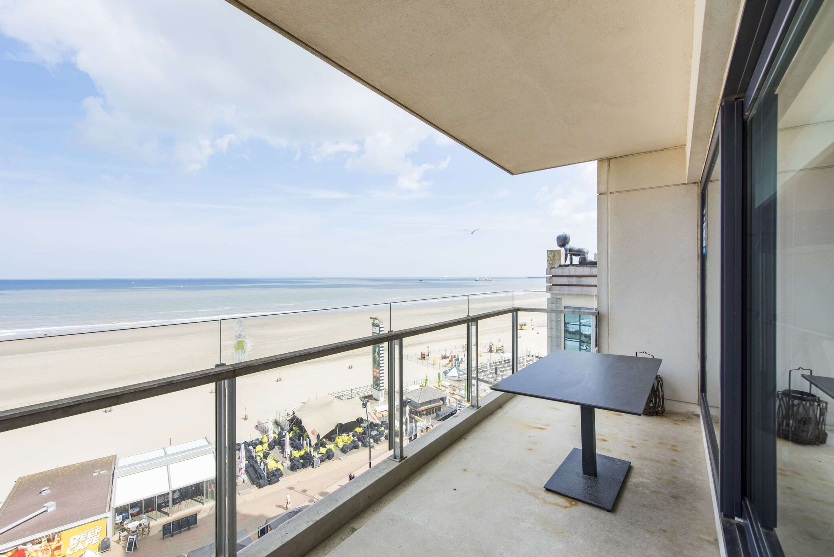 Ein Balkon mit Blick auf Strand und Meer.