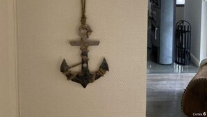 A wall with a painting of a beach path and an anchor decoration. - Heimathafen Greetsiel (Krummhoern)