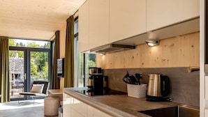 A modern kitchen with a large window, a coffee maker, and a kettle. - Holiday Home With Slide in a Holiday Park (Winterberg)