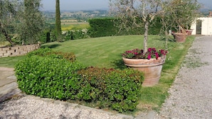A well-maintained garden with a variety of plants and a clear view of the countryside. - Belvilla by OYO Michelangelo (Castiglion Fiorentino)