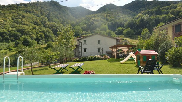 Ein Schwimmbecken mit Blick auf ein Haus und Berge.