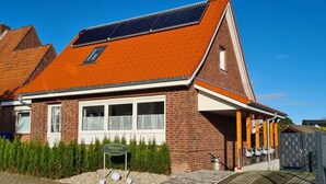 Ein Gebäude aus Backsteinen mit geneigtem Dach und Solaranlage, gekennzeichnet als Restaurant.