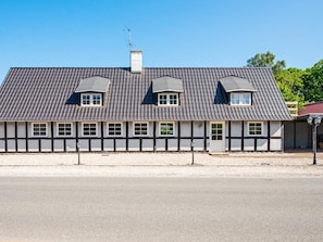 A traditional half-timbered house with a steeply pitched roof, multiple windows, and a chimney. - 10 Person Holiday Home in Auning (Auning)
