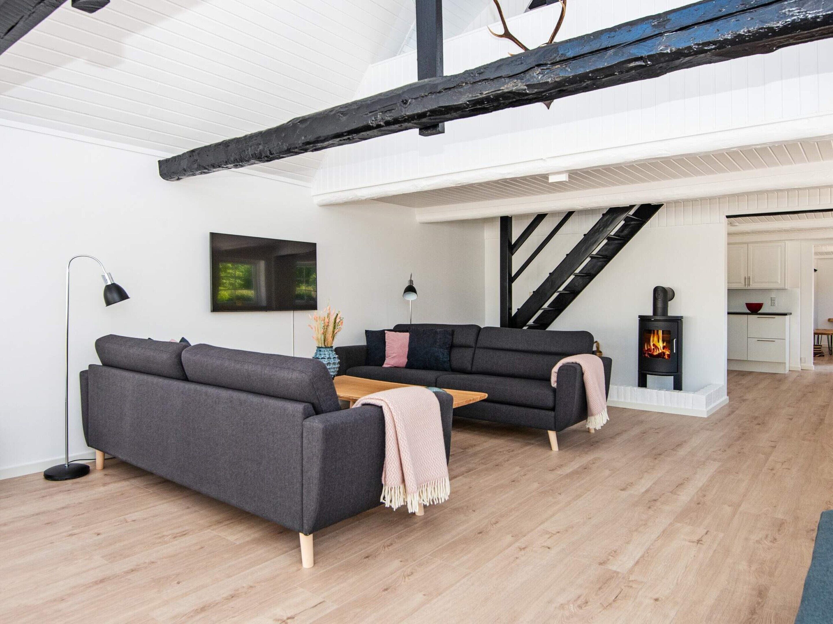 A modern living room with a sofa, a coffee table, and a fireplace.