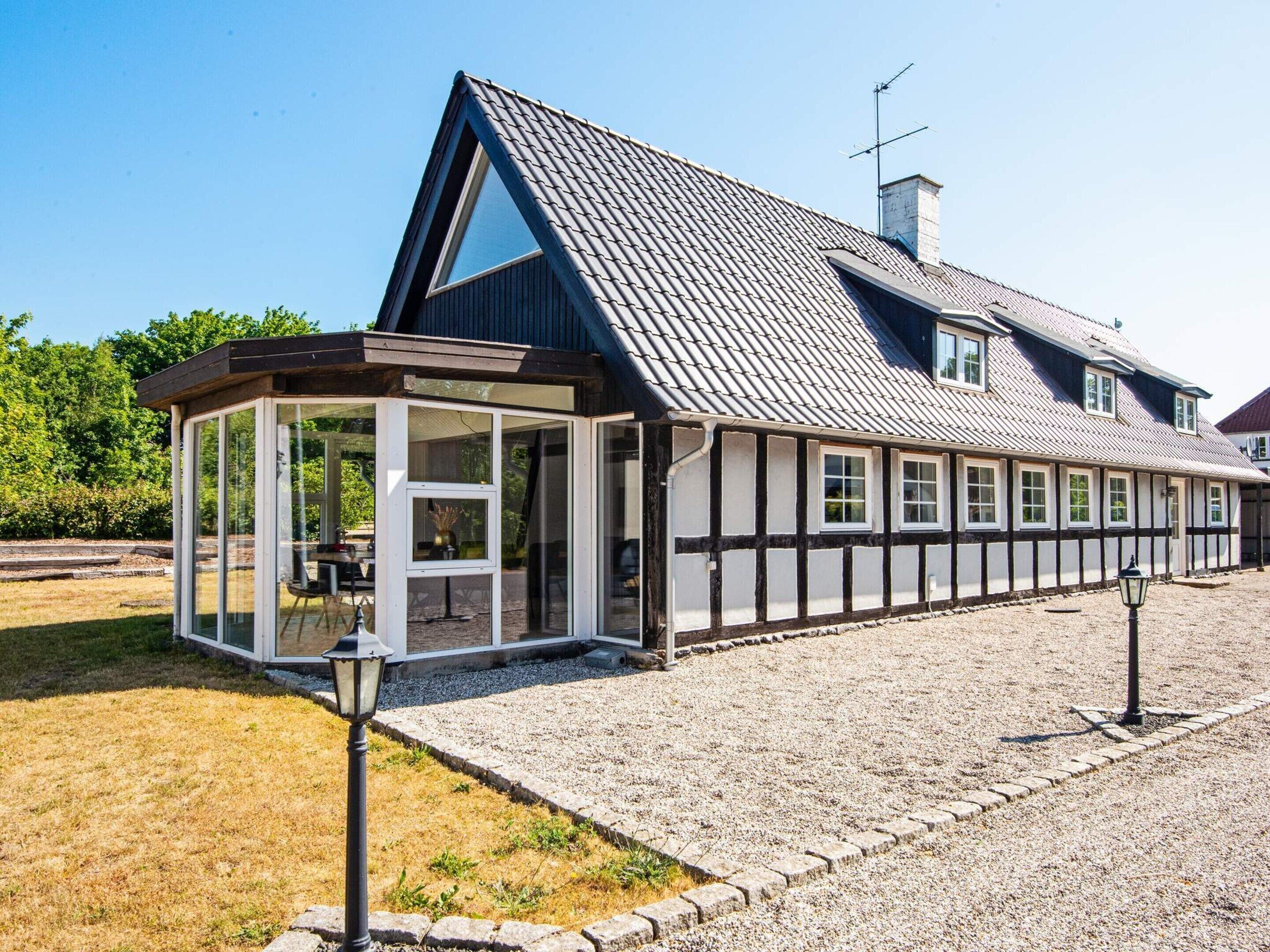 A traditional half-timbered house with a gabled roof and a glass conservatory.