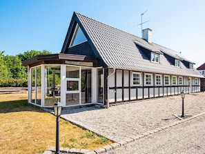 A traditional half-timbered house with a gabled roof and a glass conservatory.