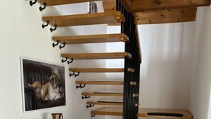 Un escalier en bois avec des marches noires et une rampe en bois.