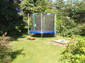 Enjoy an outdoor space with a trampoline and lush surroundings.