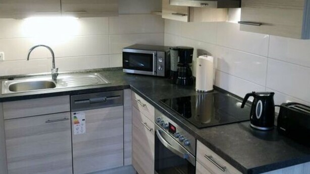 A modern kitchen with a built-in dishwasher, microwave, and oven. - \"seagull Street\" 21 Merchant (Wangerland)