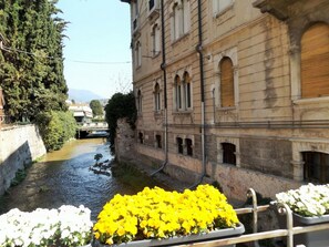 A canal with a building on one side and a bridge in the background. - Apartment in Garda Near Lake (Garda)