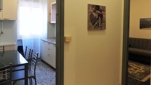 A compact kitchen with a dining area, a sofa, and artwork on the wall. - Apartment in Garda Near Lake (Garda)