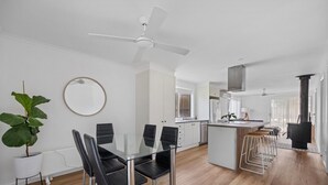 A modern kitchen with a central island, white cabinetry, and a ceiling fan.