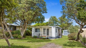 A mobile home with a porch, surrounded by trees and a grassy yard. - Prom Coast - Duneside (Sandy Point)