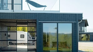 A modern building with a large glass door and a covered outdoor area. - 5 Star Holiday Home in Inderoy (Inderøy)