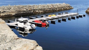 A marina with boats docked, a stone breakwater, and a mountainous backdrop. - 5 Star Holiday Home in Inderoy (Inderøy)