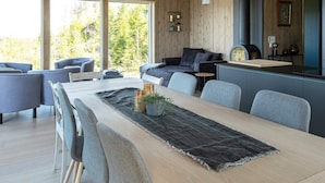 A modern interior with a dining area, sofas, and a kitchen. - 5 Star Holiday Home in Inderoy (Inderøy)