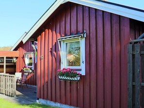 A red wooden building with a window and a flower box.